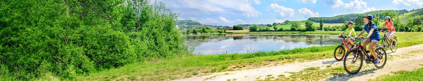 Famille à vélo au bord d'un lac
