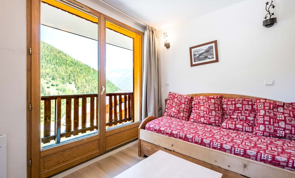 Séjour avec canapé lit Les Chalets de la Ramoure